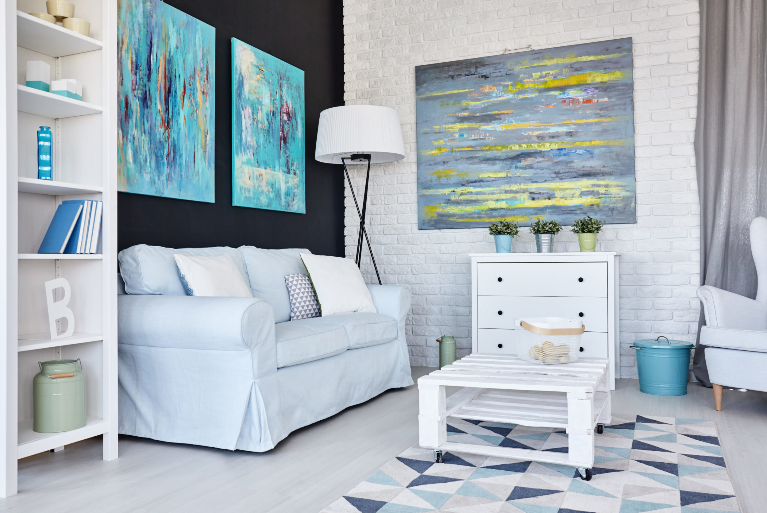 a room with a white couch and a white table and a blue and white rug